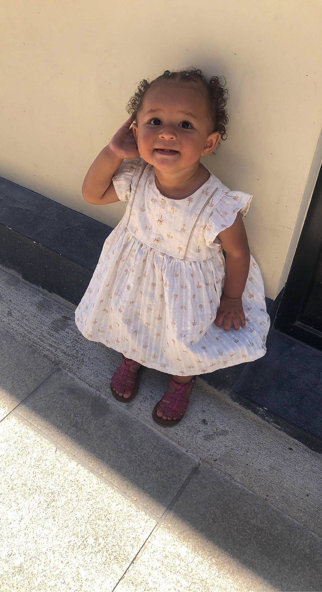 Kessy a rejoint le concours — aidez-le/la à gagner de superbes lots ! baby_toddler_clothing, child, day_dress, dress, face, facial_expression, flooring, foot, fun, happy, human_leg, pattern, person, sandal, shoulder, sitting, skin, sleeve, smile, toddler