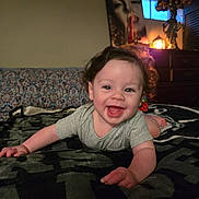 Adonis is registered to the contest to win money with this photo: baby, blanket, child, couch, cozy, curly_hair, decor, eyes, face, furniture, hand, happy, indoor, lamp, person, portrait, poster, room, smiling, toddler