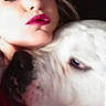 woman, dog, face, close_up, pet, affection, portrait, human, animal, white_dog, lipstick, cuddle, intimate, love, companion, indoor, head, skin, expression, nuzzle