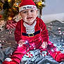 baby, child, christmas, holiday, festive, red_clothing, hat, smiling, lights, blanket, indoors, decorations, christmas_tree, happy, sitting, cute, celebration, cozy, winter, playful