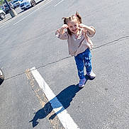 Karma joined the competition — help win amazing prizes! child, girl, smiling, parking_lot, shadow, sunny, jeans, pigtails, sneakers, asphalt, cars, playful, outdoor, casual_clothing, daytime, cute, happy, person, fun, bunny_patches