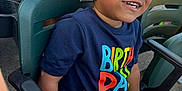 Mason joined the competition — help win amazing prizes! child, smiling, curly_hair, birthday_shirt, burger, food, stadium_seat, green_chair, casual_clothing, happy, person, outdoor, daylight, celebration, fast_food, seat_number, people, hand, jeans, leisure