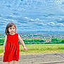 casual_shoes, child, cityscape, cloudy_sky, curious, daylight, girl, grass, greenery, nature, outdoor, person, portrait, red_dress, scenic_view, sky, standing, urban, wooden_platform, young