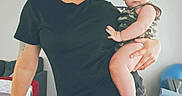 Ezra joined the competition — help win amazing prizes! adult, baby, black_tshirt, camouflage, cap, child, curious, floor, furniture, home, indoor, leggings, living_room, person, plush, pose, sock, tattoo, woman, wood_floor