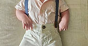 Ezra joined the competition — help win amazing prizes! baby, child, clothing, cute, face, feet, hands, happy, indoor, infant, light, lying_down, one_person, portrait, shirt, shorts, skin, smiling, soft_texture, suspenders