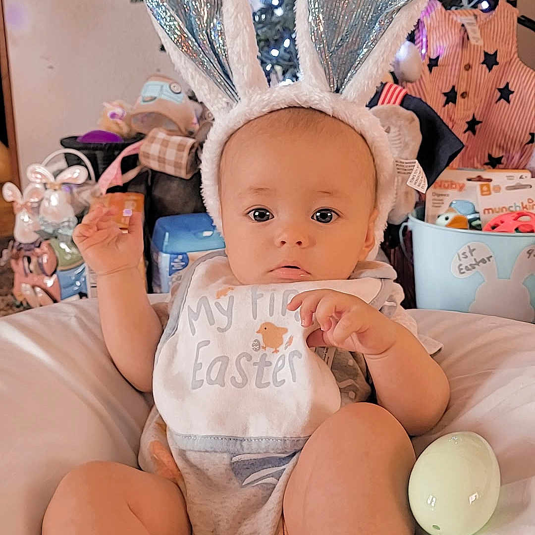 Kohen joined the competition — help win amazing prizes! baby, ball, christmas, christmasdecorations, christmastree, clothing, cricket, cricketball, face, festival, glove, hat, head, openingpresent, people, person, sitting, sleeve, sport