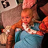 baby, man, tattoo, couch, blanket, indoor, relaxing, child, person, home, toddler, clothing, portrait, face, skin, arm, hand, fabric, furniture, living_room