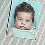 baby, infant, printed_photo, portrait, face, eyes, chubby_cheeks, hair, tank_top, striped_background, fabric, closeup, photograph, paper, lying_flat, cute, studio_backdrop, small_photo, skin, expression