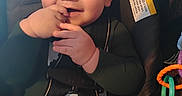 Gordon is registered to the contest to win money with this photo: baby, buckle, car_seat, cheeks, child, close_up, cute, face, fingers, green_shirt, hand, happy, indoor, infant, pants, portrait, seat_belt, smiling, toy, warning_label