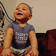 Gordon joined the competition — help win amazing prizes! baby, infant, child, onesie, smile, sitting, barefoot, headband, bedroom, brick_wall, metal_headboard, blanket, pajamas, cheeks, toes, hands, portrait, indoor, happy, slogan_on_clothing