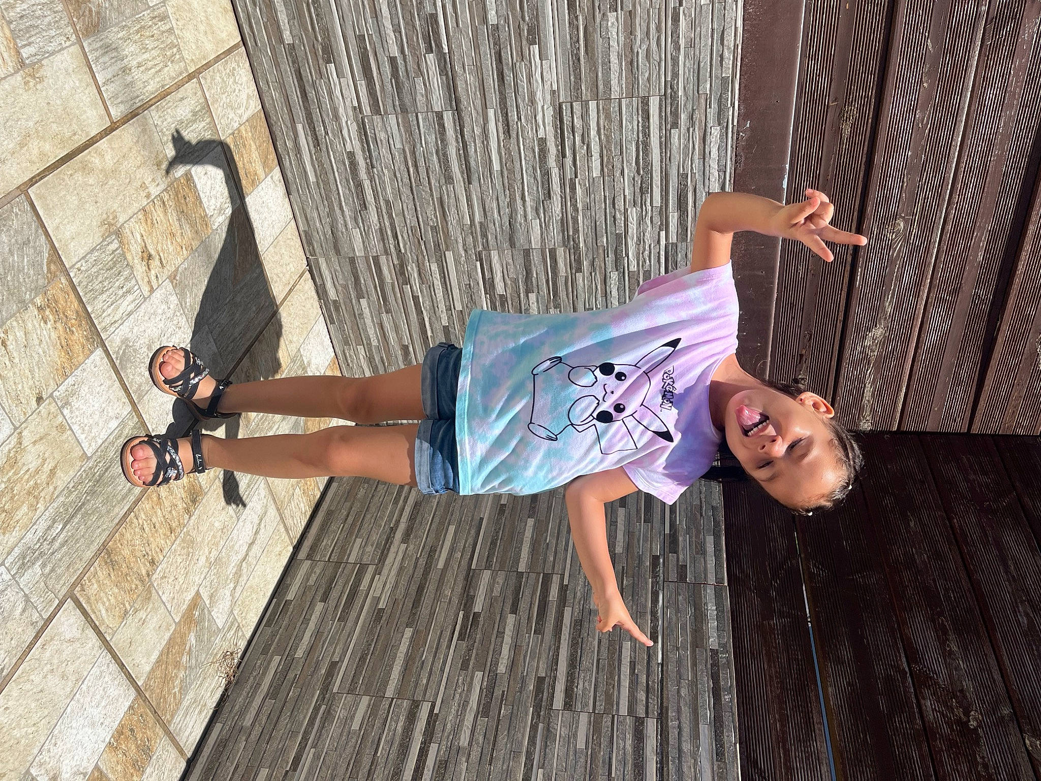 Marie participe au concours pour gagner de l'argent avec cette photo : denim, electric_blue, flash_photography, flooring, foot, fun, happy, hardwood, human_leg, leisure, pattern, person, sandal, sitting, street, t_shirt, thigh, waist, wood, wood_stain