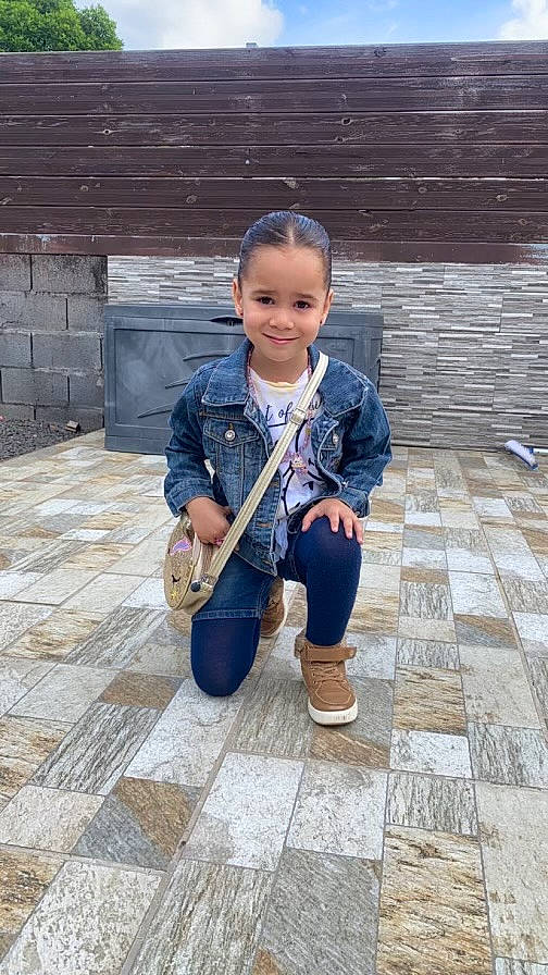 Marie participe au concours pour gagner de l'argent avec cette photo : boot, child, city, cobblestone, concrete, electric_blue, face, flooring, fun, joy, leisure, pattern, person, road_surface, shoe, sidewalk, sitting, smile, temple, toddler