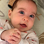 Anaëlle participe au concours pour gagner de l'argent avec cette photo : baby, infant, face, hands, blue_eyes, clothing, patterned_outfit, lying_down, blanket, animal_print, closeup, cute, skin, expression, portrait, child, soft_texture, newborn, happy, person