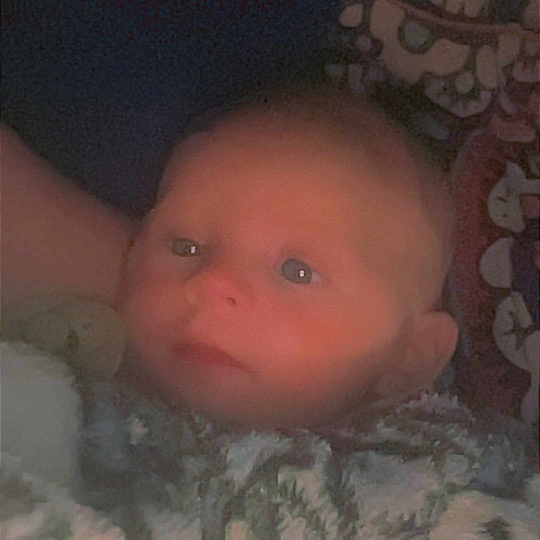Remmi is registered to the contest to win money with this photo: baby, blanket, face, infant, child, portrait, cozy, soft_light, indoor, warm, cute, young, sleepy, resting, wrapped, blue, pattern, closeup, newborn, toddler