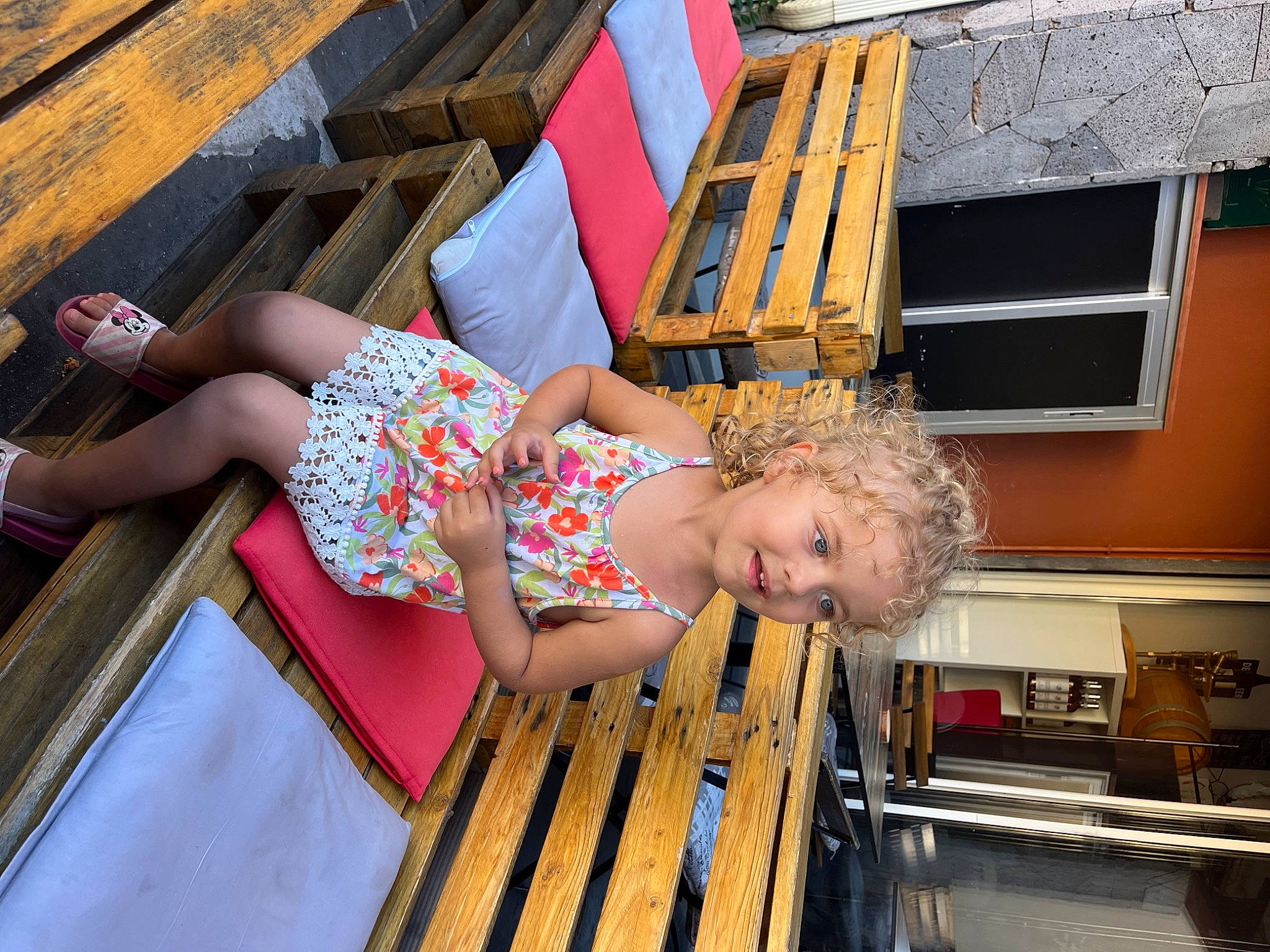 Melia a rejoint le concours — aidez-le/la à gagner de superbes lots ! baby_toddler_clothing, barefoot, building, child, flip_flops, flooring, foot, fun, happy, house, human_leg, leisure, outdoor_furniture, pattern, person, sandal, smile, thigh, toddler, window