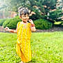 child, girl, yellow_dress, traditional_clothing, smiling, outdoor, grass, greenery, nature, playful, happy, sunny, bracelets, barefoot, portrait, young, cute, cheerful, daylight, posing