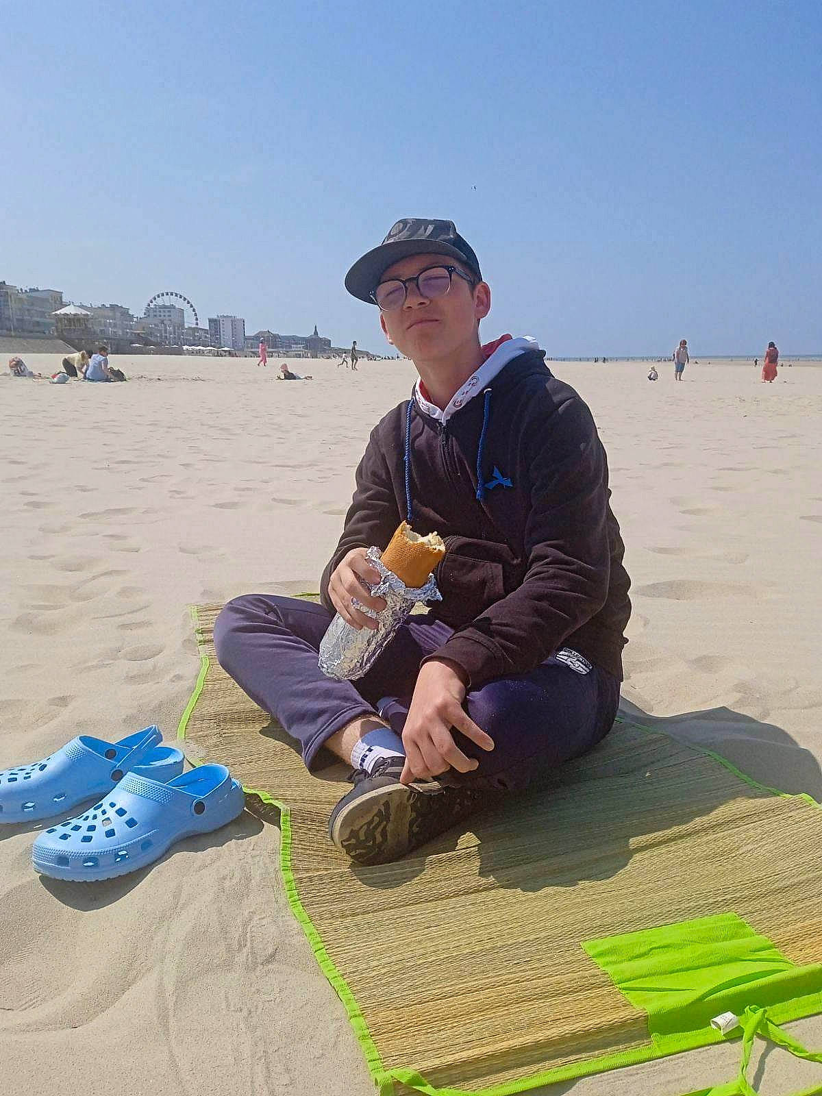 Anzo participe au concours pour gagner de l'argent avec cette photo : baseball_cap, beach, cap, coast, fun, hat, headwear, horizon, landscape, leisure, ocean, people_in_nature, person, recreation, sand, singing_sand, sitting, sky, soil, tourism