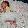Kel'Lis is registered to the contest to win money with this photo: baby, newborn, child, infant, angel_wings, tutu, white_clothing, bed, bedding, milestone_blanket, portrait, lying_down, indoor, cozy, infant_photography, curly_hair, side_profile, pink, numbers, family_photo
