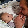 Kel'Lis is registered to the contest to win money with this photo: baby, infant, adult, parent, affection, kiss, hand, bottle, feeding, blanket, bed, bedroom, indoor, portrait, family, tender, lying_down, close_up, caregiving, sleepy