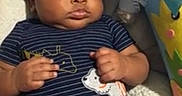 Da'Marko is registered to the contest to win money with this photo: baby, infant, child, portrait, lying_down, indoors, onesie, striped_clothing, stuffed_animal, plush_toy, couch, blanket, pillow, nursery, happy, awake, face, hands, toys, photography