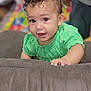 Brielle joined the competition — help win amazing prizes! baby, child, curly_hair, green_clothing, indoor, playroom, soft_surface, face, hand, eyes, cute, infant, portrait, smiling, person, toddler, skin, expression, couch, background