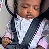 baby, sleeping, car_seat, harness, blanket, onesie, infant, child, peaceful, cute, hands, portrait, seatbelt, resting, indoors, closeup, face, head_support, clothing, secure