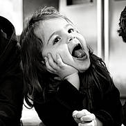 Emma a rejoint le concours — aidez-le/la à gagner de superbes lots ! child, black_and_white, happy, smiling, face, hands, floor, long_hair, portrait, indoor, expression, cute, joyful, person, young, playful, closeup, emotion, casual, candid