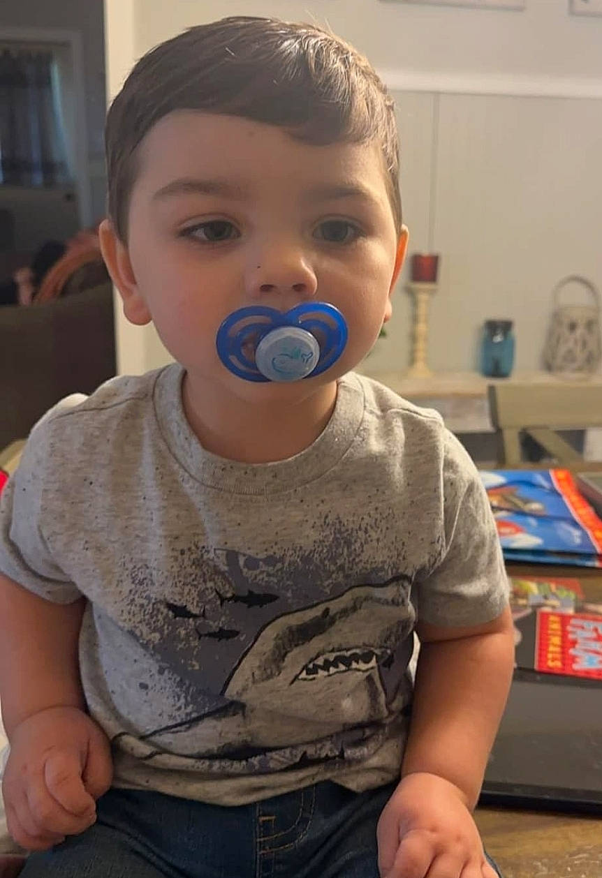 Kashton is registered to the contest to win money with this photo: baby, baby_toddler_clothing, cheek, child, chin, denim, drinkware, facial_expression, finger, flooring, fun, happy, nose, person, play, sitting, skin, t_shirt, thumb, toddler