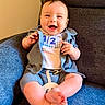 baby, boy, smiling, happy, sitting, blue_armchair, clothing, shirt, shorts, infant, cute, celebration, half_birthday, indoors, portrait, child, feet, hands, face, warm_lighting