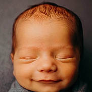 Bentlee joined the competition — help win amazing prizes! newborn, baby, infant, sleeping, smiling, face, portrait, close_up, wrapped, blanket, gray, cozy, peaceful, indoors, soft_lighting, warm_tones, head, closed_eyes, photography, adorable