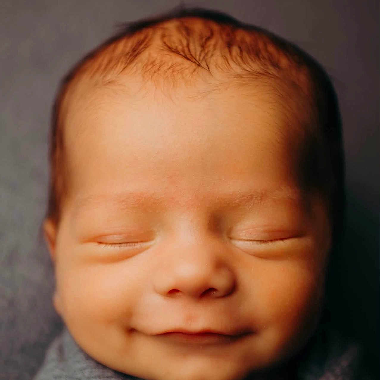 Bentlee joined the competition — help win amazing prizes! newborn, baby, infant, sleeping, smiling, face, portrait, close_up, wrapped, blanket, gray, cozy, peaceful, indoors, soft_lighting, warm_tones, head, closed_eyes, photography, adorable