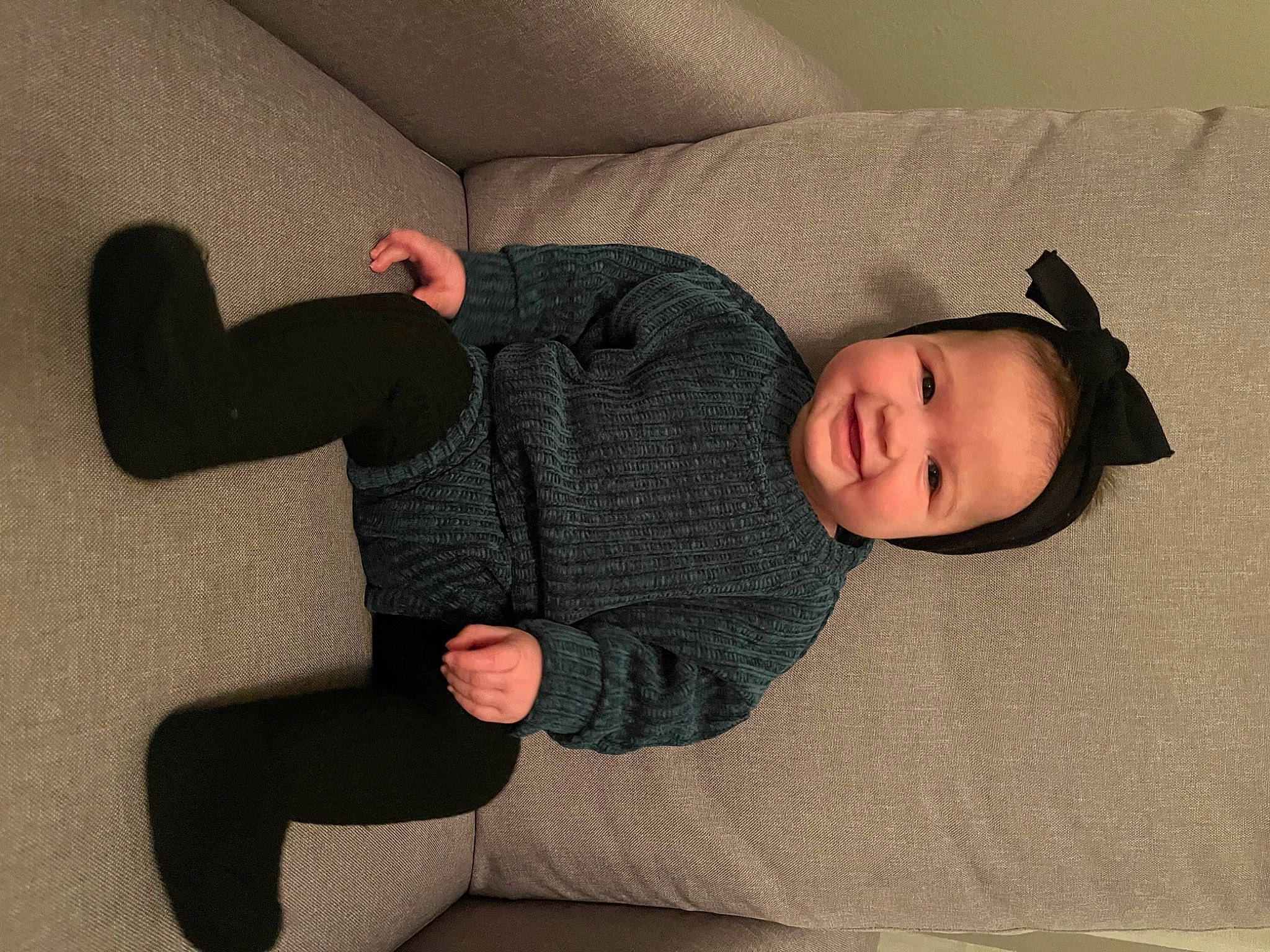 Lillian is registered to the contest to win money with this photo: baby, baby_toddler_clothing, comfort, eye, face, facial_expression, finger, gesture, grey, hand, head, headgear, human_body, joy, knee, leg, person, skin, sleeve, sock