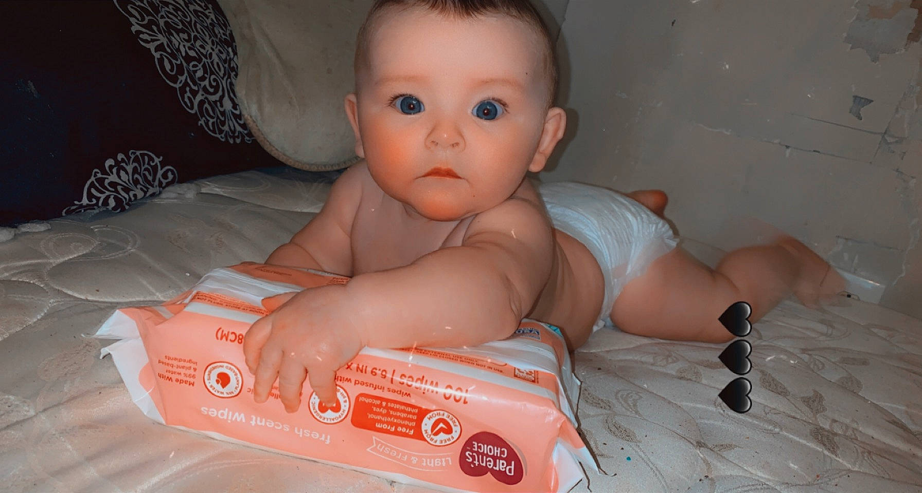 Eva is registered to the contest to win money with this photo: arm, baby, baby_toddler_clothing, cheek, chest, child, comfort, eye, finger, flooring, fun, human_leg, mouth, nail, nose, person, sitting, skin, surprise, thumb