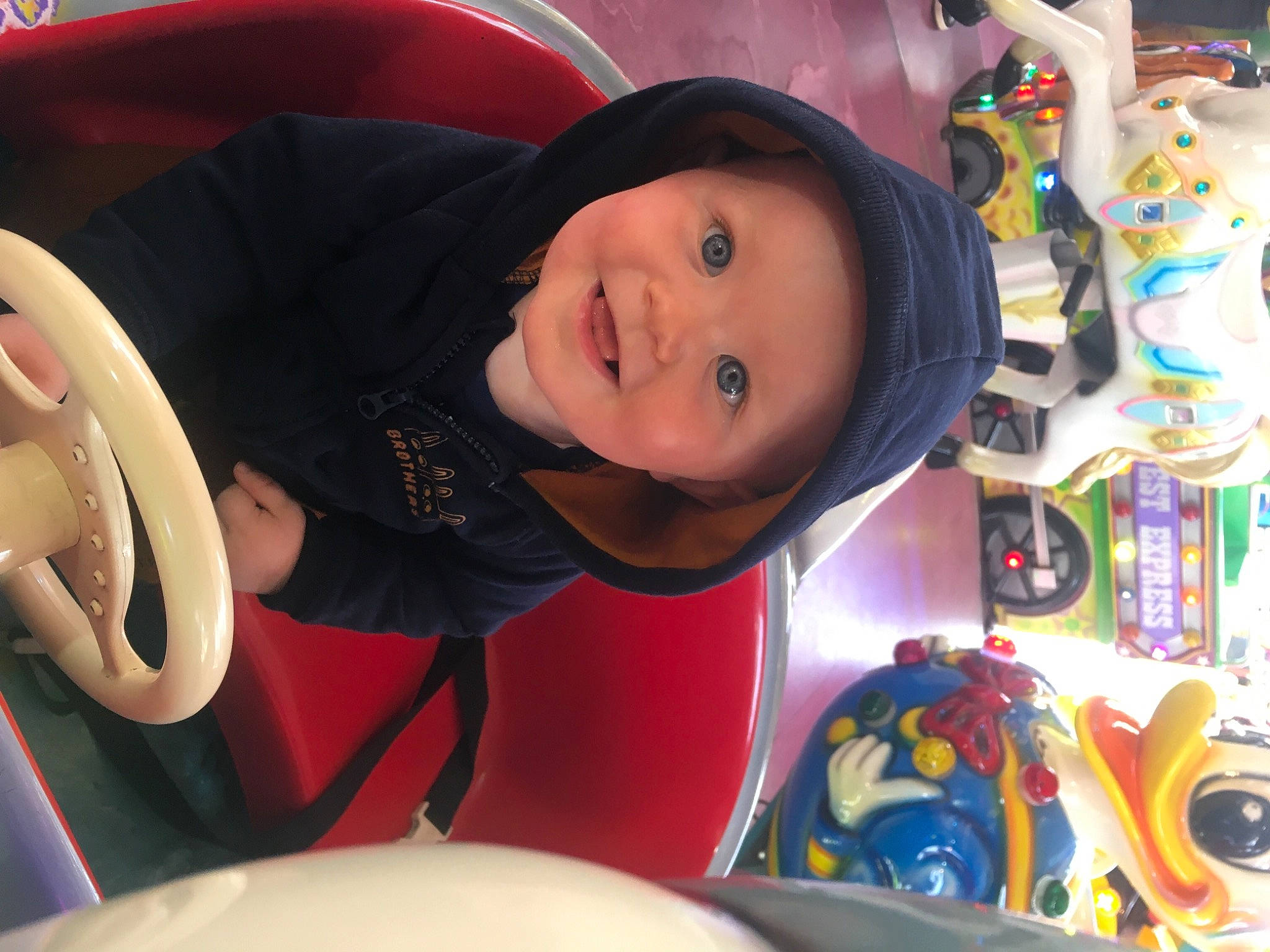 Dario participe au concours pour gagner de l'argent avec cette photo : auto_part, baby, cap, cheek, child, event, fun, happy, hat, headwear, hoodie, jacket, joy, leisure, person, product, recreation, smile, steering_wheel, toddler