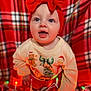 baby, child, red_bow, headband, christmas_lights, festive_sweater, gingerbread_man, christmas_tree, santa_claus, plaid_blanket, holiday, indoors, cute, smiling, happy, portrait, infant, colorful_lights, celebration, warm