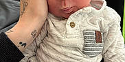 Demetry joined the competition — help win amazing prizes! baby, child, closeup, clothing, comfort, cute, expression, face, hand, holding, indoor, infant, knitwear, onesie, person, pucker, sitting, skin, striped_pocket, tattoo