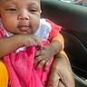 Jaliyah Aka Cookie is registered to the contest to win money with this photo: baby, infant, child, portrait, face, eyes, car, vehicle, interior, seated, pink_clothing, dress, polka_dots, adult_hand, caregiver, city, storefront, window, daylight, close_up