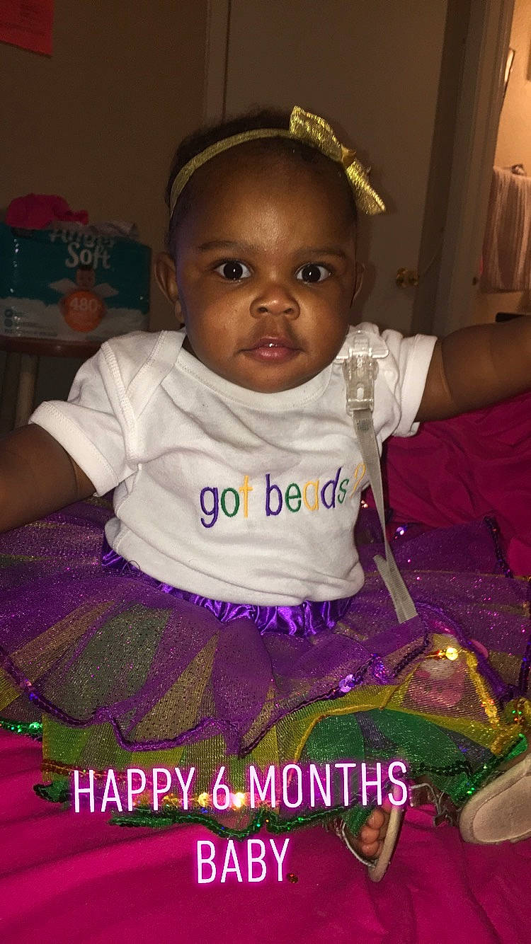 Kelsie is registered to the contest to win money with this photo: baby, baby_toddler_clothing, cheek, child, forehead, fun, happy, head, person, photo_caption, pink, purple, sitting, skin, smile, toddler