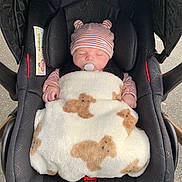 Patrick participe au concours pour gagner de l'argent avec cette photo : baby, infant, car_seat, blanket, pacifier, hat, striped_clothing, sleeping, cute, child, teddy_bear_pattern, cozy, outdoor, safety, headwear, newborn, resting, adorable, baby_boy, comfort