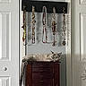 Shark is registered to the contest to win money with this photo: cat, sleeping, jewelry, necklaces, wooden_chest, indoor, furniture, decor, relaxation, tail, shadow, home, peaceful, resting, ornaments, hanging, closed_eyes, animal, pet, cabinet