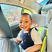 Nathaniel joined the competition — help win amazing prizes! toddler, child, car_seat, smiling, happy, indoors, seatbelt, clothing, overalls, car_interior, sunlight, window, safety, young_child, portrait, person, cute, seat, car, daylight