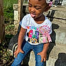 child, toddler, birthday, outdoor, sunlight, concrete, steps, hair_clips, pink, shirt, minnie_mouse, jeans, smile, tongue_out, person, grass, fence, shadow, dollar_bill, ribbon