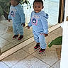 toddler, child, mirror, reflection, blue_hoodie, pants, sneakers, indoor, tile_floor, plant, smile, standing, person, casual_clothing, young_child, cute, happy, fashion, portrait, home