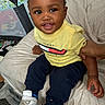 Antonio joined the competition — help win amazing prizes! toddler, child, smiling, yellow_shirt, navy_pants, sneakers, bed, hand, playpen, indoor, happy, person, portrait, clothing, footwear, baby, cute, sitting, home, infant