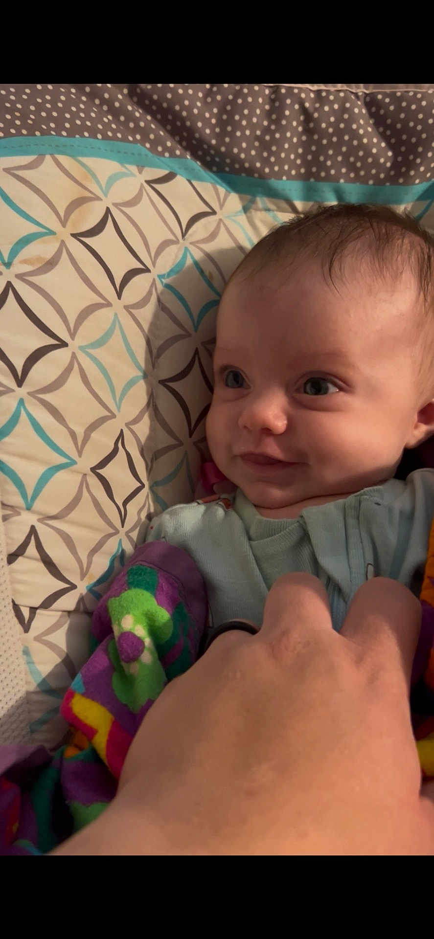 Mazilen is registered to the contest to win money with this photo: baby, infant, smile, hand, blanket, pattern, colorful, face, eyes, cute, child, clothing, bed, comfort, playful, skin, person, portrait, baby_girl, baby_boy