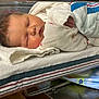 newborn, baby, sleeping, blanket, hospital, bassinet, towel, hand, face, infant, clothing, bed, healthcare, patient, rest, cozy, cute, peaceful, skin, hospital_room