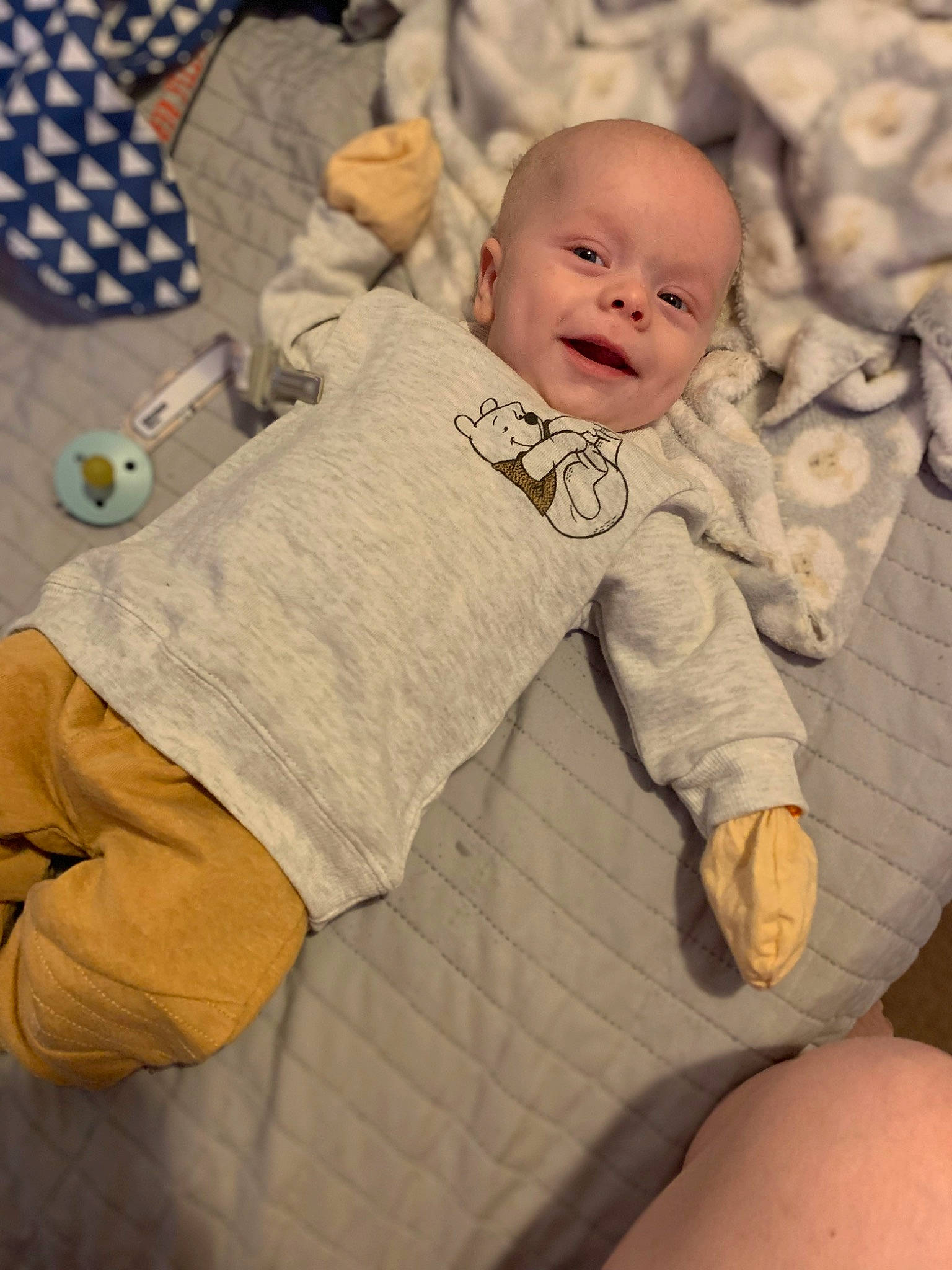 Jaxson is registered to the contest to win money with this photo: arm, baby, baby_sleeping, baby_toddler_clothing, cheek, comfort, face, finger, gesture, happy, knee, linens, pattern, person, sitting, skin, sleeve, smile, textile, thigh