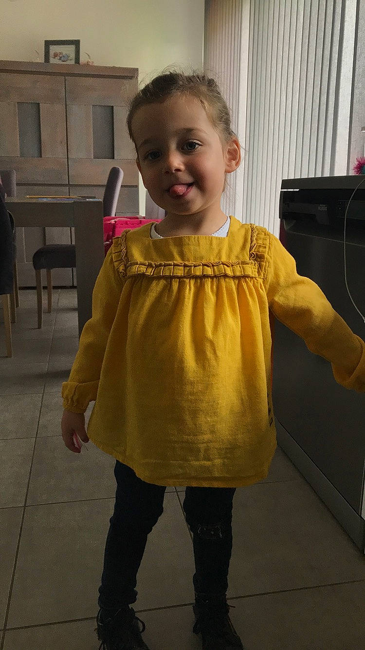 Evaelle participe au concours pour gagner de l'argent avec cette photo : child, clothing, day, dress, footwear, fun, girl, joint, joy, outerwear, person, shoulder, sleeve, smile, standing, t_shirt, textile, toddler, top, yellow
