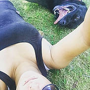 Spaz is registered to the contest to win money with this photo: animal, black_dog, casual_clothing, dog, grass, happy, lip_piercing, lying_down, nature, outdoor, person, pet, playful, relaxation, selfie, smile, summer, sunglasses, tongue, tongue_out