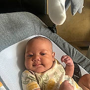 Journee is registered to the contest to win money with this photo: baby, infant, smiling, onesie, lemon_pattern, bouncer, blanket, mobile, soft_toys, chubby_cheeks, portrait, closeup, home_interior, cozy, warm_light, hand, arm, skin, relaxed, gaze